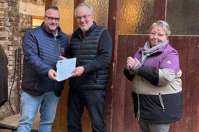 Staatssekretär Andy Becht überreicht den Förderbescheid an Matthias Becker und Doris Leininger-Rill